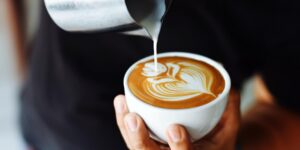 a coffee being poured with an intricate design