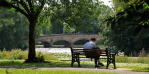 A man sitting on a bench in a park