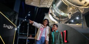 National Space Centre - lady and boy walking under Soyez rocket and pointing at display
