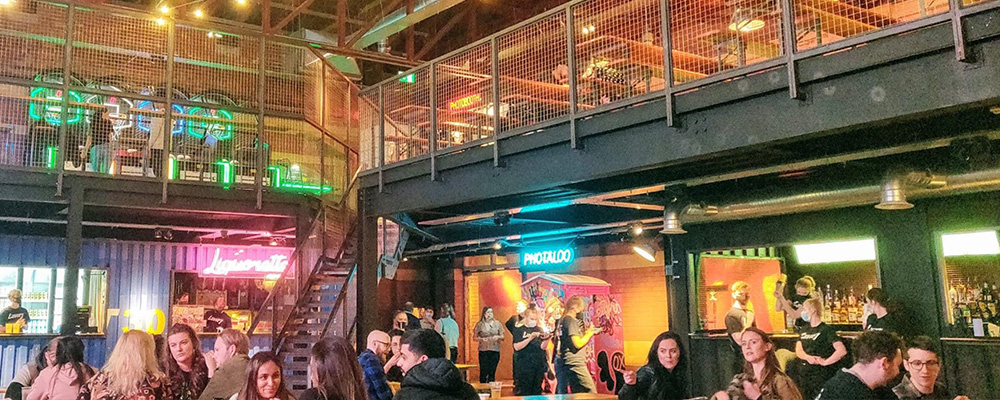 The interior of an arcade with people sat drinking and eating