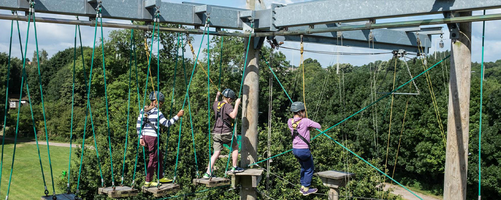 children walking on a highropes course