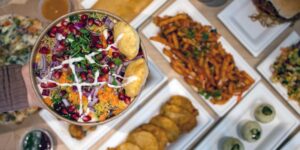 a bowl of indian street food alongside other snacks