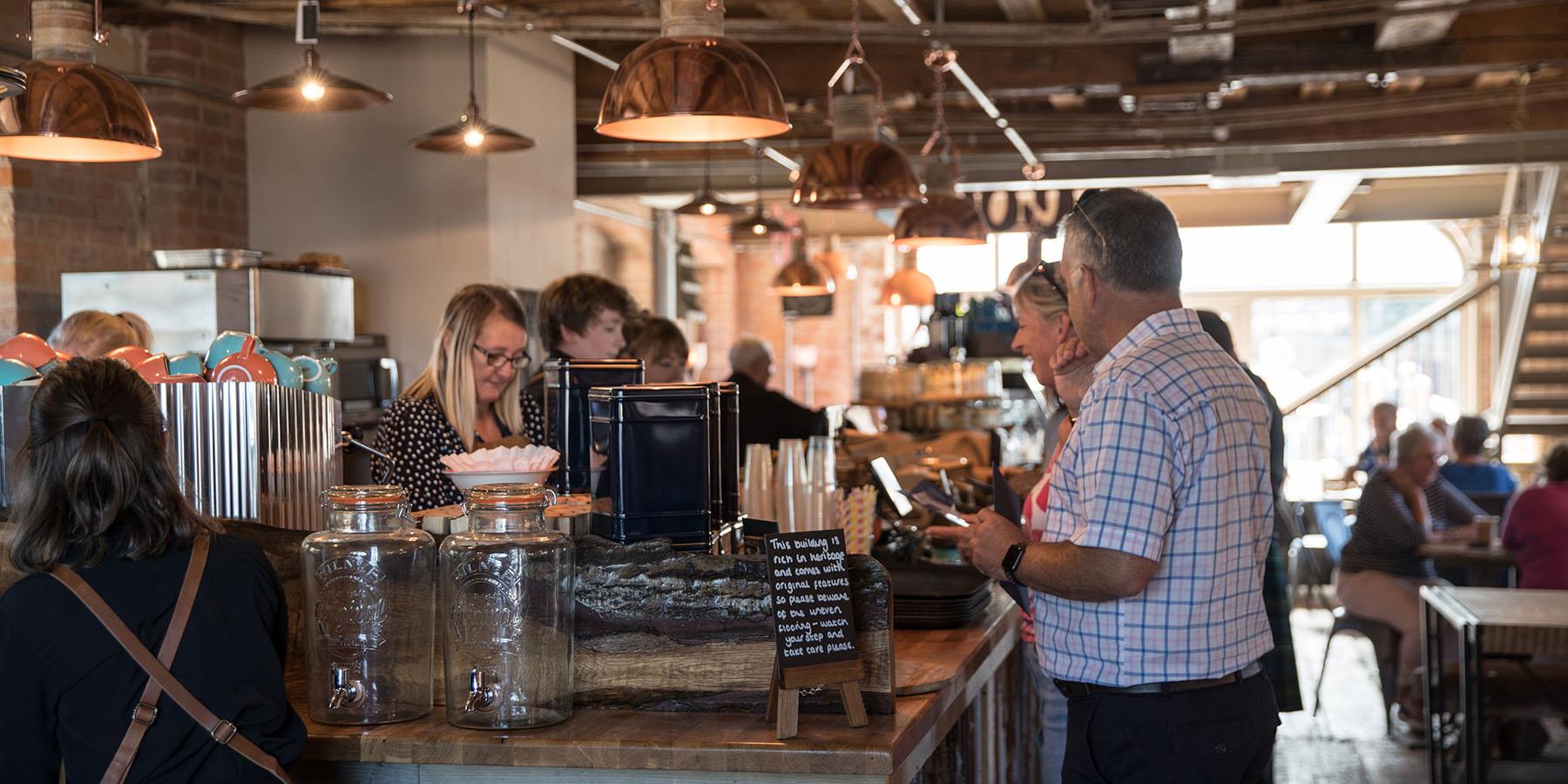 A busy cafe with people at the counter