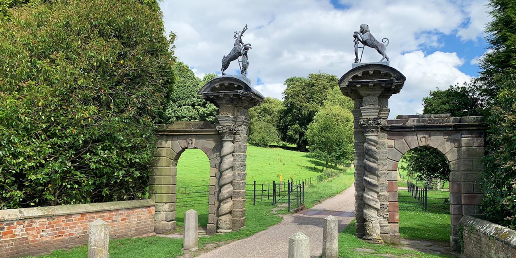 an archway entrance to a long driveway