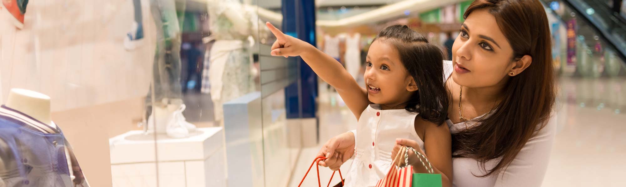 A mother and daughter looking in a shop window
