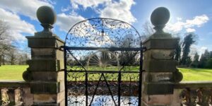 Iron gate looking over a green lawn