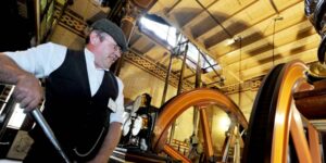 A man in flat cap in front of the Pumping Station Beam Engines