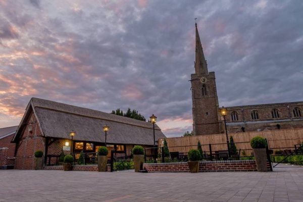 barn and church lit up at sunset