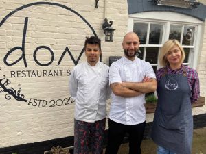 chefs stood outside of a restaurant