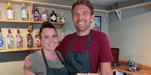 two people at the counter of a shop
