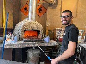 chef with wood fired pizza oven