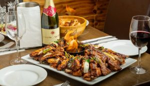 turkish food on plate alongside glass of wine