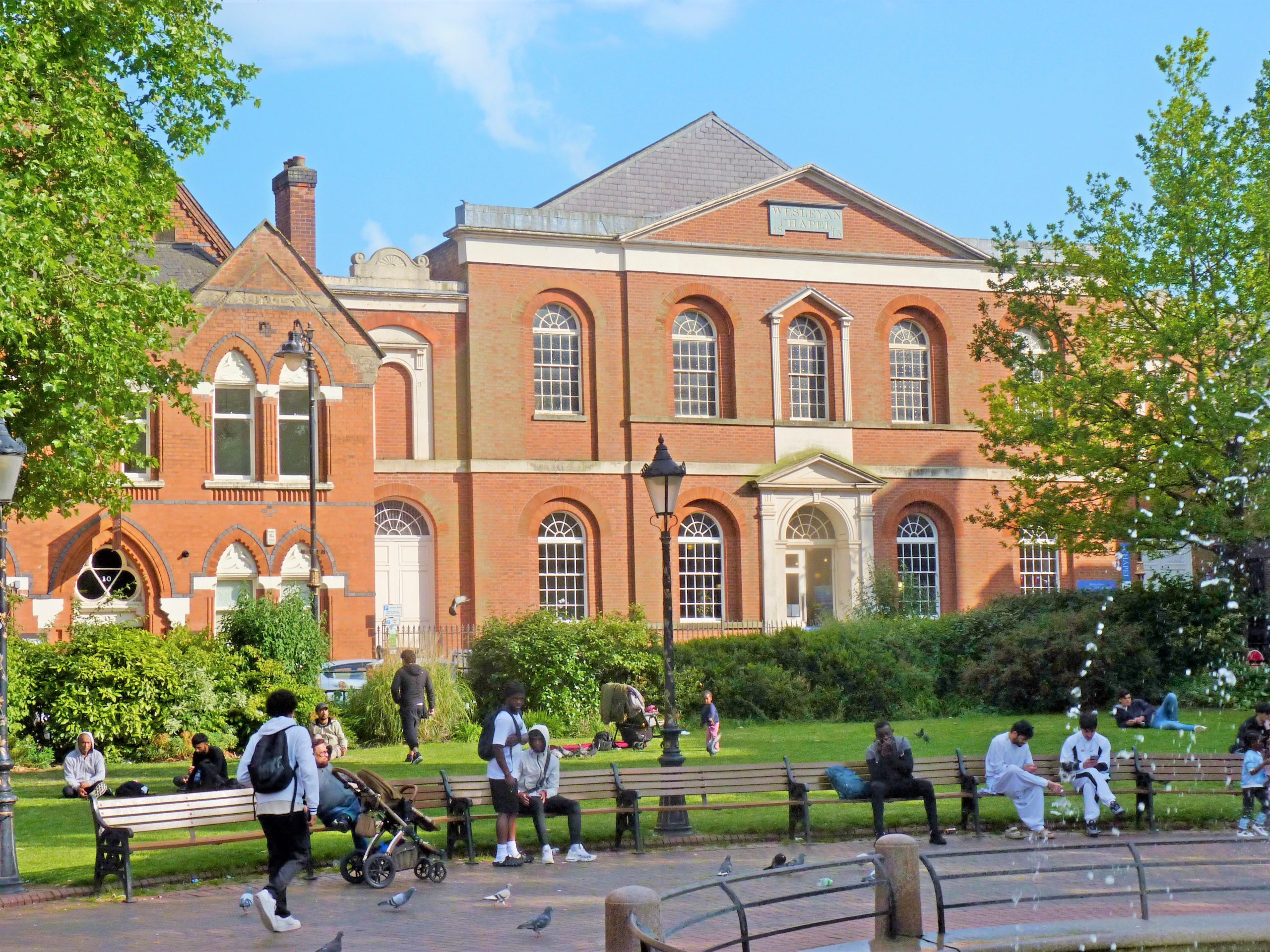 exterior of building with people sat on benches outside