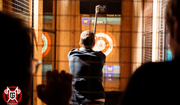 man throwing an axe at a target