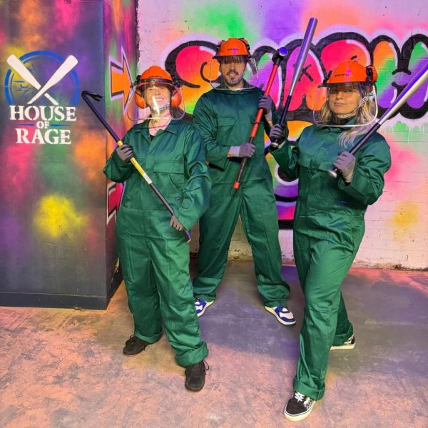 people standing with protective gear at a rage room