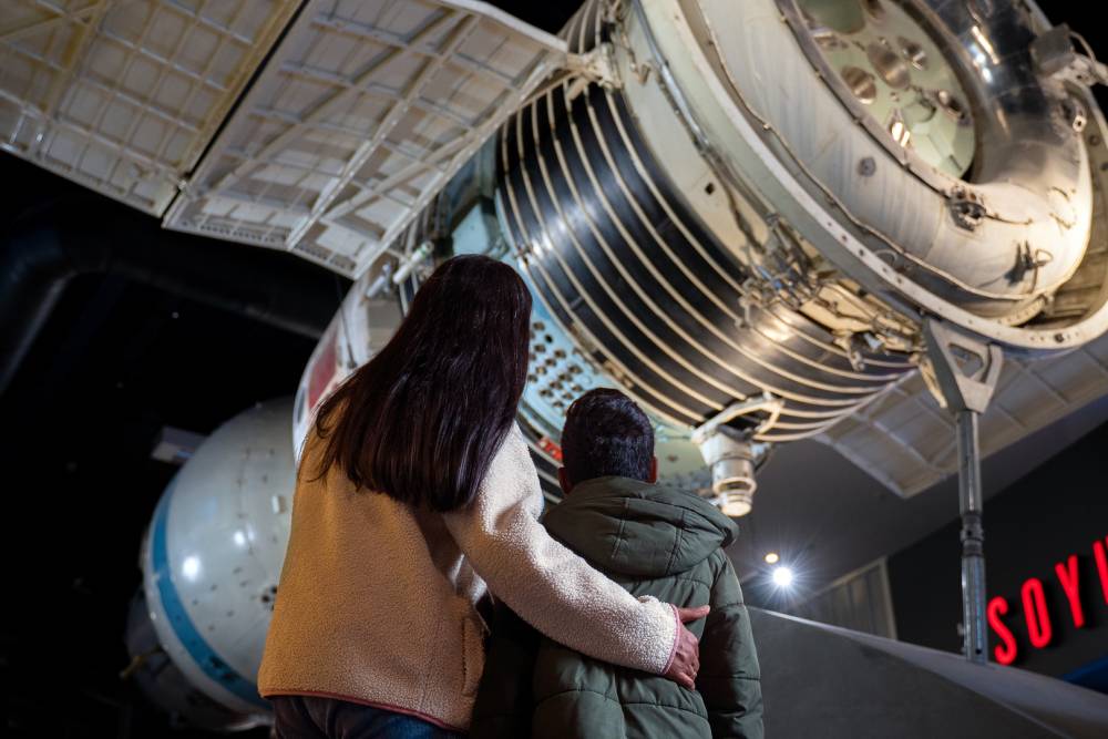 two people looking at a spaceship in a museum