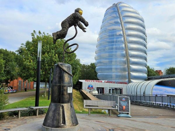 Exterior of national space centre with statue and rocket tower building